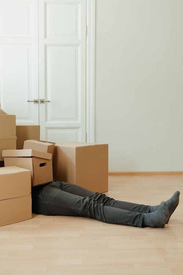 Chronic fatigue and vitamin deficiency: Man overwhelmed by boxes symbolizing nutrient depletion