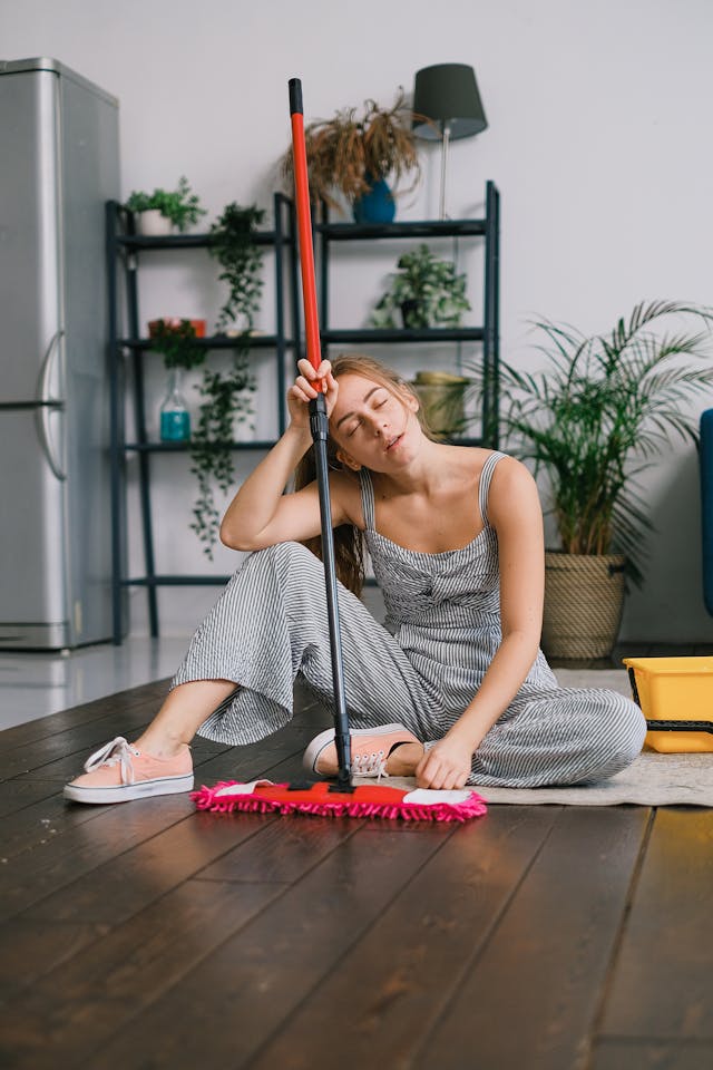 Exhausted woman asleep while cleaning, showing extreme fatigue from lack of sleep.