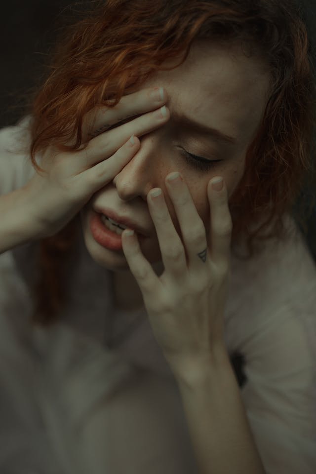 Young woman tired covering eyes, signaling afternoon slump from vitamin deficiency