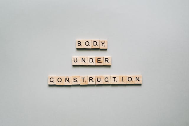 Wooden blocks spelling "body under construction" on a gray background, symbolizing the transformation process with the Metabolic Reset Diet.