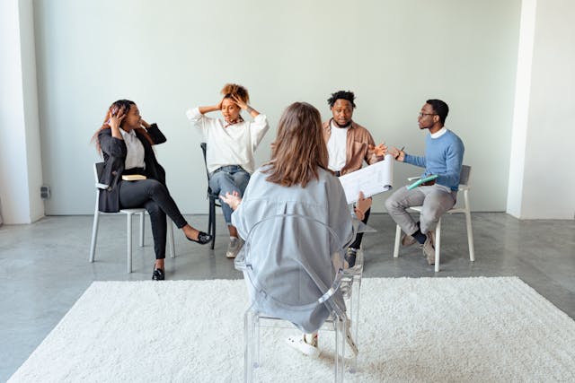 Support group helps quit smoking - real people sharing stories People in a circle discussing smoking issues, symbolizing the benefits of group therapy and support in learning how to quit smoking successfully.