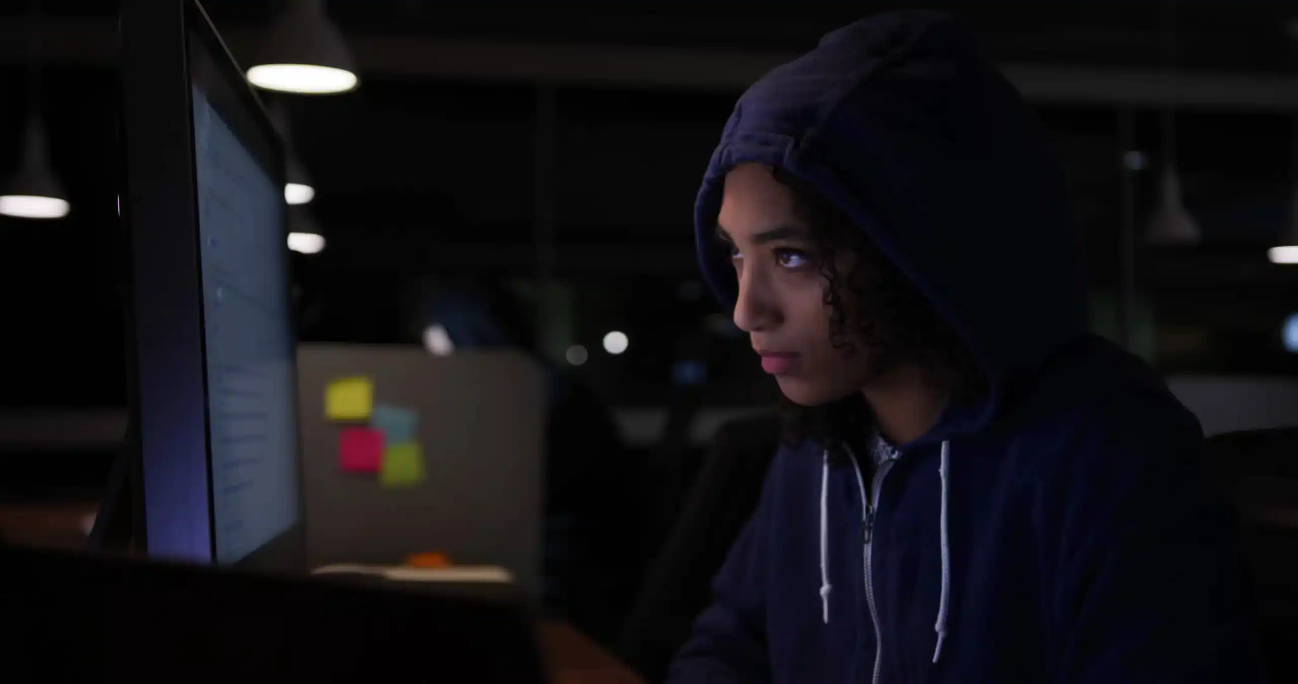 Woman in a hoodie working late at night on a computer illustrating circadian fasting for shift workers