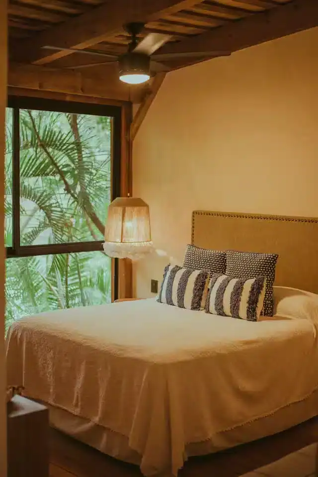 Cozy bedroom with a hanging ceiling fan, illustrating an ideal sleep environment for sleep hygiene during menopause